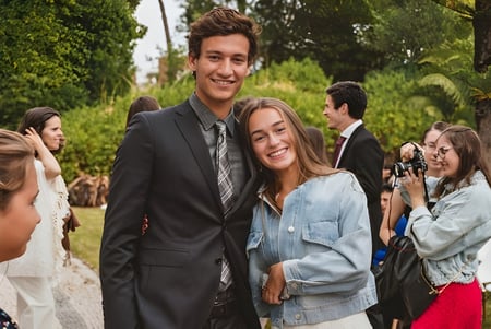 Una joven pareja está junta y sonríe en un área verde al aire libre en el campus de Greene's College Oxford.