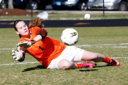 Una futbolista atrapa el balón en el campo de Greensboro Day School.