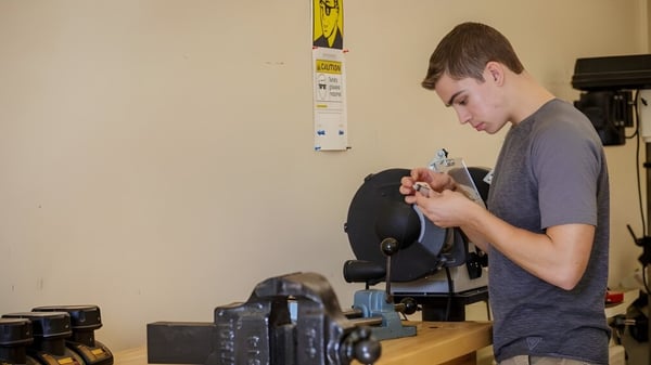 Un estudiante del Groton-Dunstable Regional School District trabaja concentrado en un dispositivo en el taller.