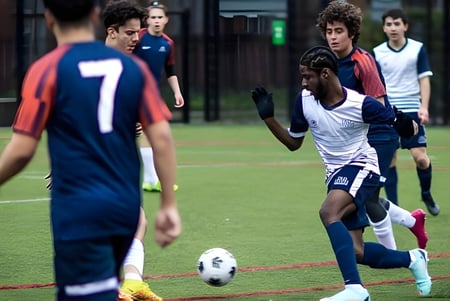 Los estudiantes de la Guildhouse School London juegan al fútbol en un campo de césped.