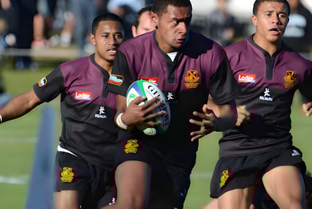 Un grupo de jugadores de rugby lleva sus camisetas color marrón durante el partido en el campo de la Hamilton Boy's High School.