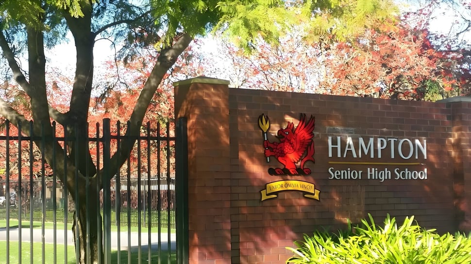 El cartel de ladrillo de Hampton Senior High School está frente a árboles coloridos.