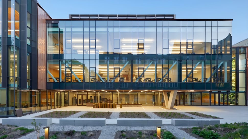 El moderno edificio de vidrio y acero de varios pisos con patio del Havergal College bajo un cielo azul claro.