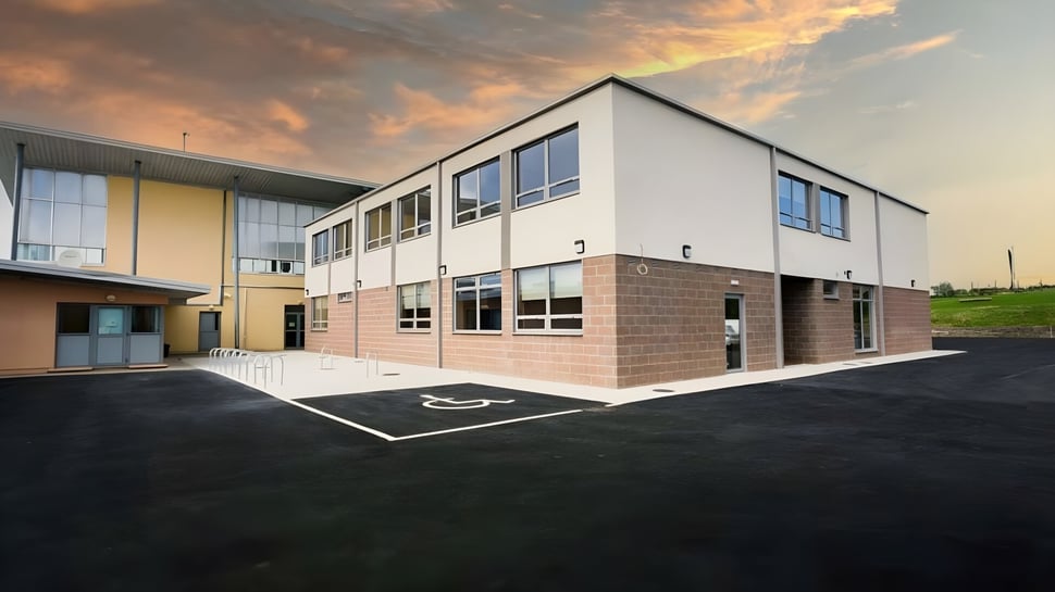 El moderno edificio de dos pisos del Hazelwood College se encuentra frente a un colorido atardecer.