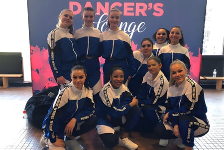 Un grupo de jóvenes bailarines posan juntos frente al letrero Danger's Lounge en el terreno de Heritage Regional High School.
