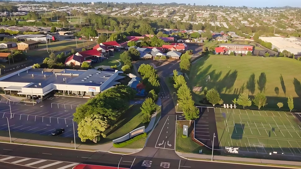 Vista de un barrio residencial con campos deportivos y un entorno verde cerca de Highlands Christian College.