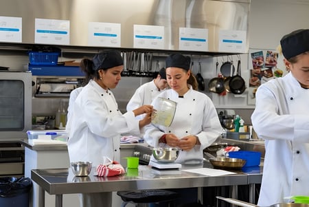 Estudiantes de la Hillmorton High School trabajan juntos en la cocina de la escuela en la preparación de alimentos.