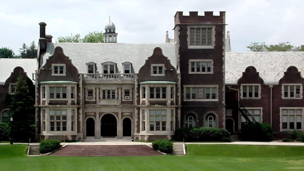 El Hobart College muestra un imponente edificio parecido a un castillo con torres y ventanas de arco en un amplio césped.