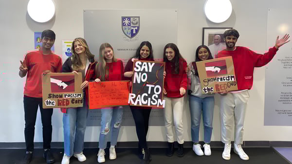 Alumnas y alumnos de la Holy Rood High School sostienen carteles en una demostración por la diversidad y contra el racismo.