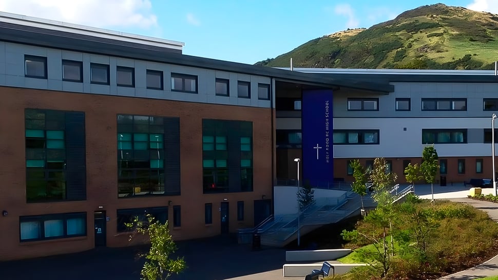 El moderno edificio de varios pisos de la Holy Rood High School está rodeado de exuberante vegetación.