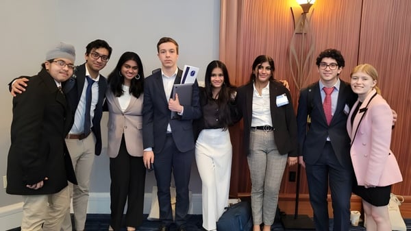 Un grupo de personas posan en un marco formal en el campus del Hopkinton Public School District.