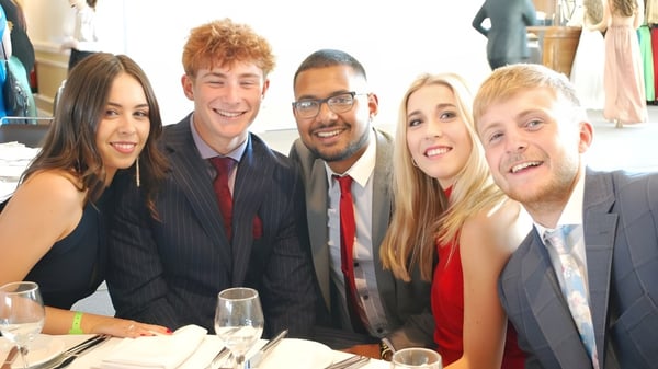 Cinco personas vestidas formalmente posan juntas en una foto grupal en la Howard of Effingham School.