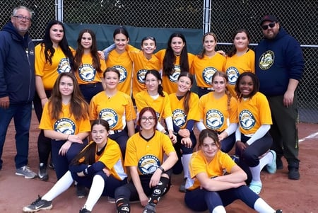 Un grupo de estudiantes de la Howard S. Billings High School posan juntos en el campo de béisbol.
