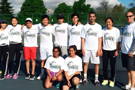 El equipo de tenis de la Hugh McRoberts Secondary School posa junto en la cancha de tenis.