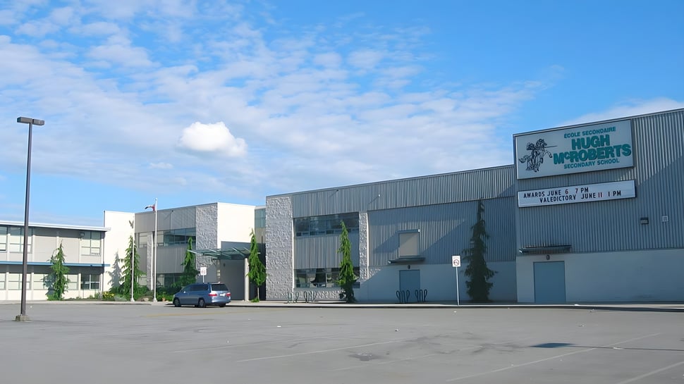 Un gran edificio industrial con un cartel de Home Depot en el terreno de la École Secondaire Hugh McRoberts Secondary School.