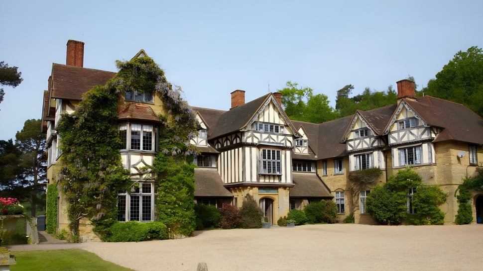 La mansión de estilo Tudor en el campus de Hurtwood House está rodeada de exuberante vegetación.