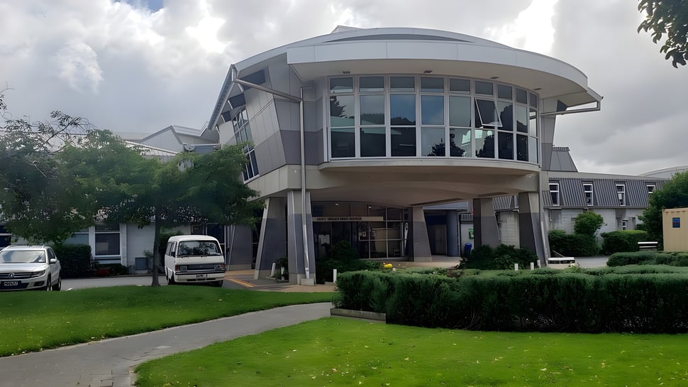 El moderno edificio de Hutt Valley High School posee una fachada de vidrio curvada y un techo en forma de cúpula en un cuidado espacio verde.