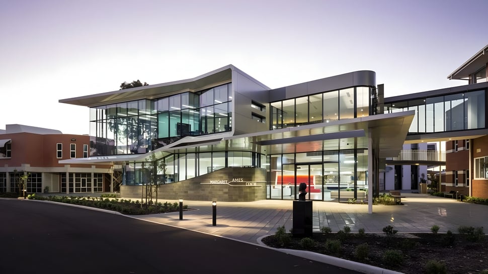 El moderno edificio del Immanuel College con fachada de vidrio está rodeado de jardines diseñados.
