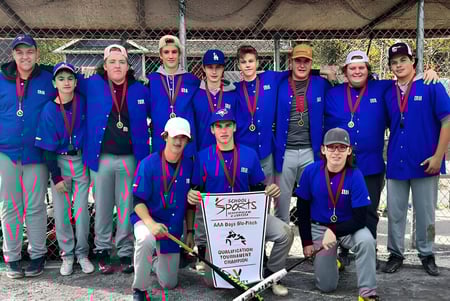 Estudiantes en uniformes azules con medallas están juntos frente al área cercada de Kids Sports de Indian River High.