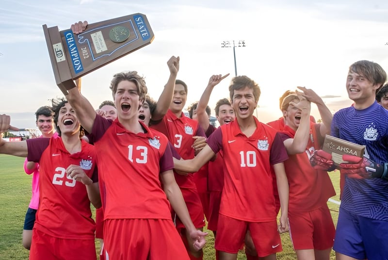 Un grupo de estudiantes de fútbol de la Indian Springs School celebra su victoria frente al marcador.