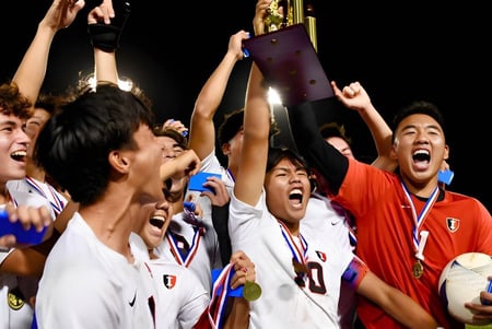 Estudiantes de la Iolani School celebran juntos su victoria frente a un estadio.