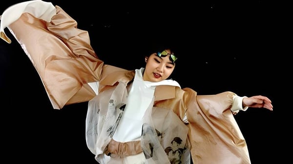 Una persona en un traje beige realiza una actuación de baile en el escenario de la International School of Creative Arts (ISCA).