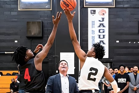 Dos jugadores de baloncesto luchan por el balón en la cancha del John Polanyi Collegiate Institute.