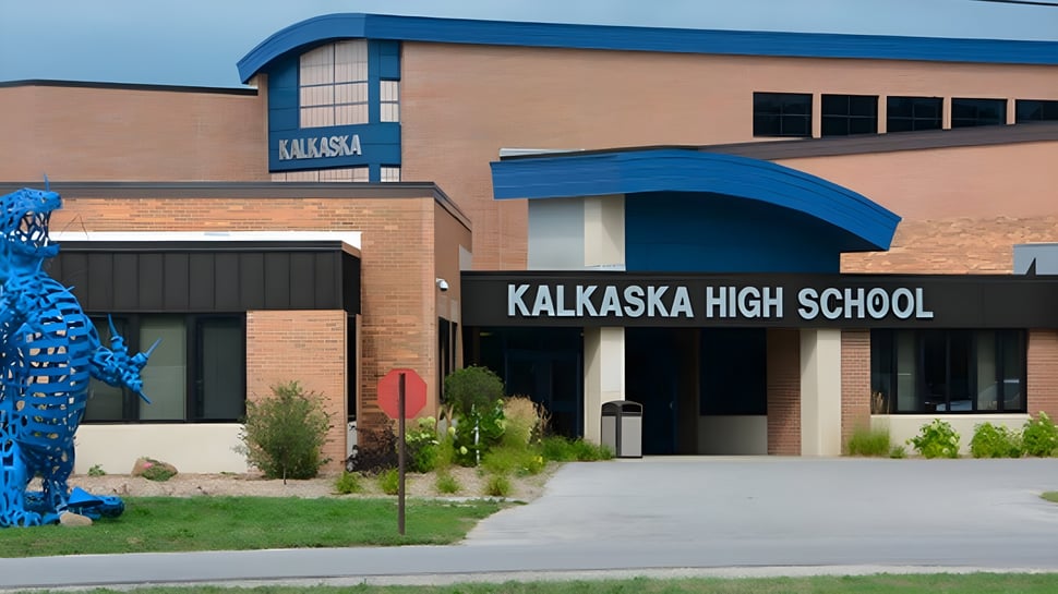 El moderno edificio de ladrillo con acentos azules y el letrero Kalkaska High School en la entrada principal.