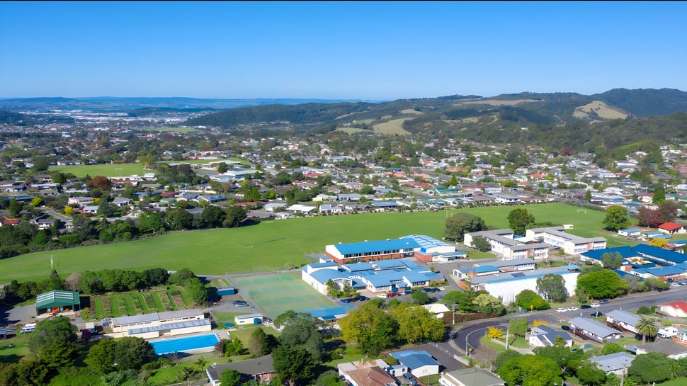 Un paisaje pintoresco con casas coloridas y campos verdes cerca de la Kamo High School.