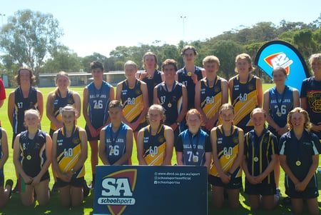 Un grupo de jóvenes atletas posan juntos en el campo de deportes de la Kapunda High School.