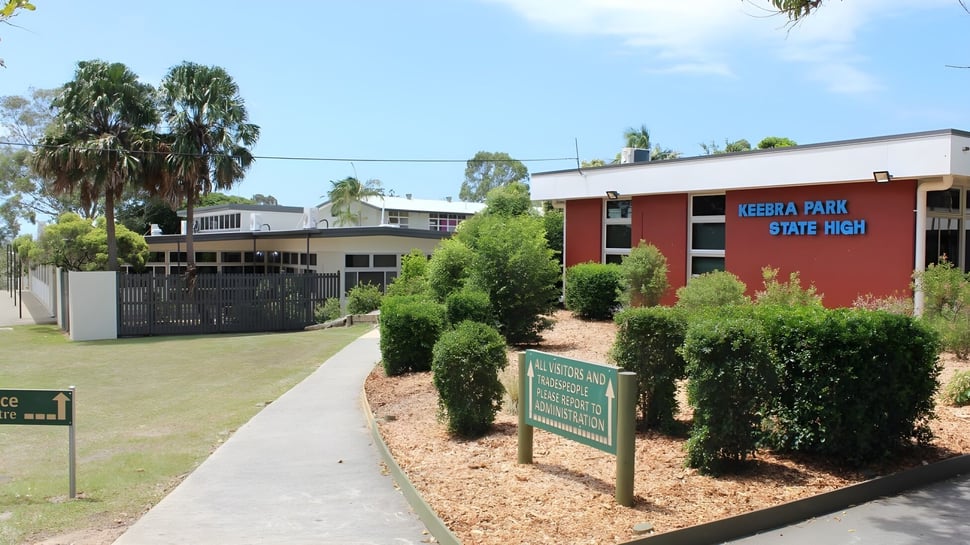 El camino pavimentado lleva a través de un jardín diseñado hasta el edificio de ladrillo rojo de la Keebra Park State High School.