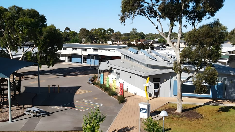 El moderno edificio de varios pisos con fachadas de colores de la Keith Area School está rodeado de árboles y áreas verdes.