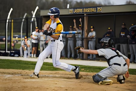 Un jugador de béisbol de la Kettle Moraine High School está en el plato en el campo de béisbol con un receptor detrás.