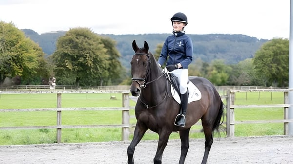 Una persona vestida de montar está sentada sobre un caballo marrón en el terreno de la Kilgraston School.