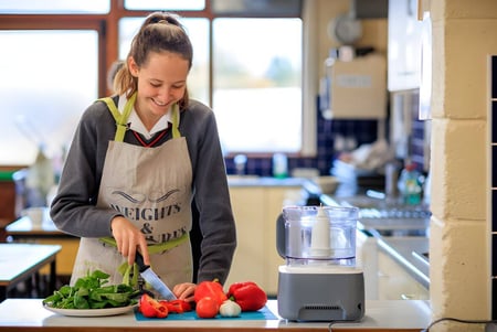Una estudiante del Kilkenny College prepara verduras frescas en la cocina de la escuela.