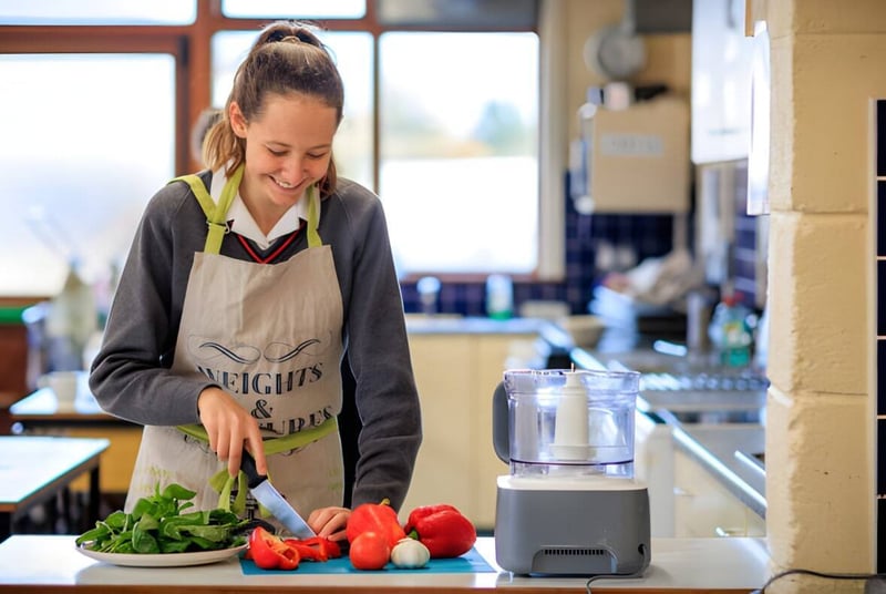 Una estudiante del Kilkenny College prepara verduras frescas en la cocina de la escuela.