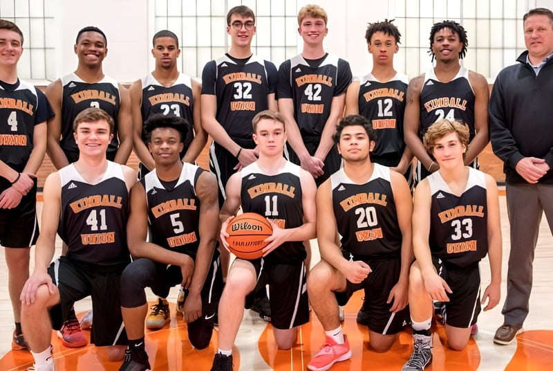 Un grupo de jóvenes jugadoras y jugadores de baloncesto posan en el gimnasio de la Kimball Union Academy.