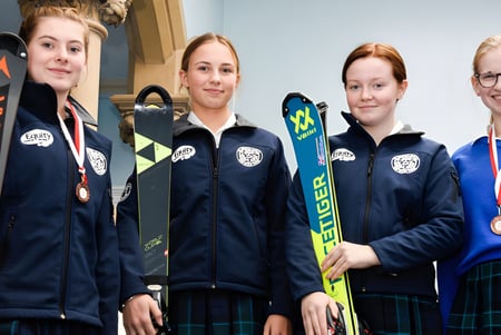 Cuatro alumnas de la Kingsley School están con equipo de esquí en un centro de entrenamiento.