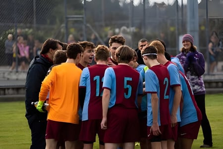 Un grupo de estudiantes del Kuranui College está junto en un campo deportivo.