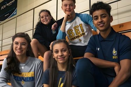 Un grupo de estudiantes de la École secondaire publique L'Académie de la Seigneurie posando en el gimnasio.
