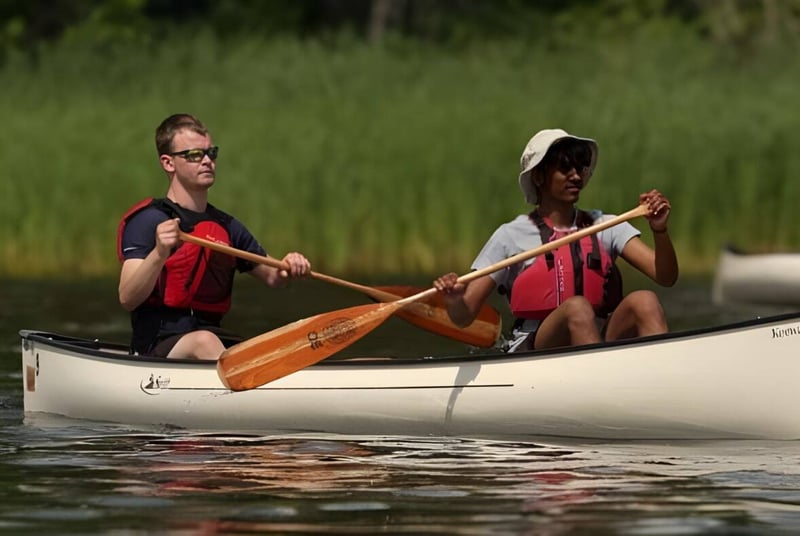 Dos personas reman en un canoa en aguas tranquilas en el campus de la Lakefield College School.