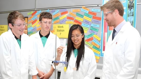 Estudiantes de la Lakeland Senior High School discuten juntos un experimento en el laboratorio.