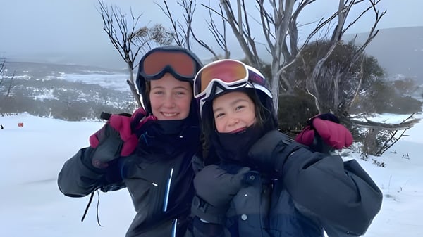 Una mujer y un niño están vestidos con ropa de invierno cálida en un bosque nevado en el terreno de la Lambton High School.