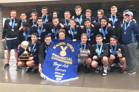 El equipo de fútbol de la Langley Fundamental Middle and Secondary School posa junto a un trofeo en un gimnasio.