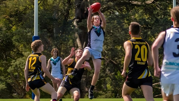 Estudiantes de Launceston College juegan al aire libre y un jugador intenta atrapar la pelota.