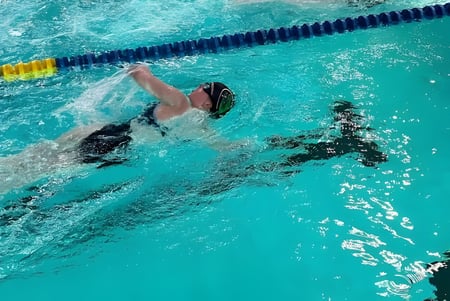 Una estudiante de la Laurel School nada en el agua clara de la piscina a lo largo de una línea de marcación.
