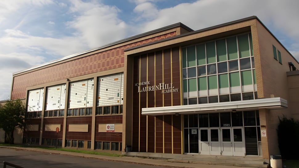 El gran edificio de ladrillo de la LaurenHill Academy se encuentra frente a un cielo nublado.