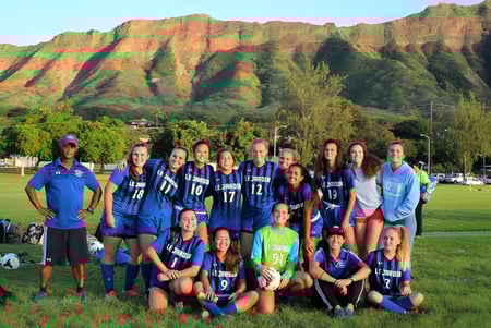 Un grupo de jóvenes futbolistas posa frente al paisaje montañoso en el campus de la Le Jardin Academy.