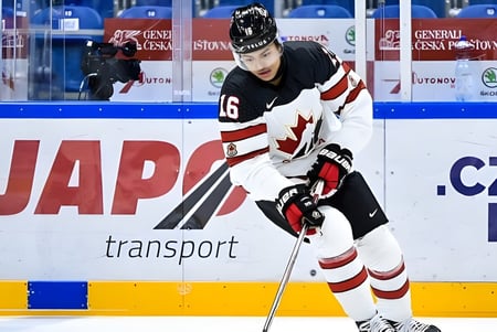 Un jugador de hockey sobre hielo con uniforme blanco y rojo patina sobre el hielo en el terreno de la Leo Hayes High School.
