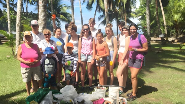 Un grupo de personas está frente a vegetación tropical en el terreno de la Lewes Old Grammar School.